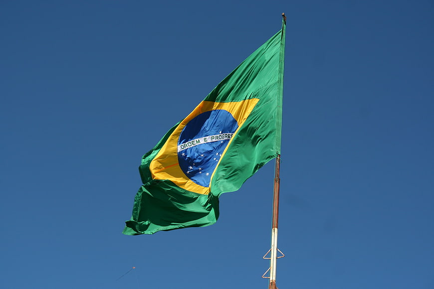Brazilian flag waving against clear blue sky