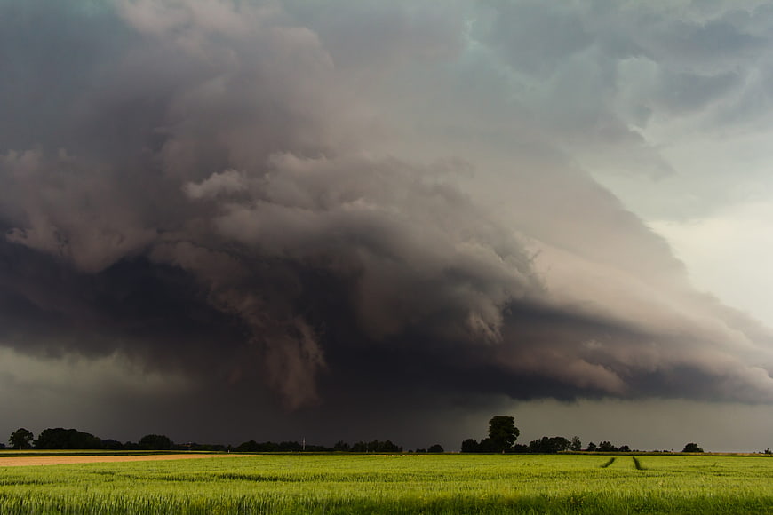Dramatic supercell thunderstorm over green agricultural fields
