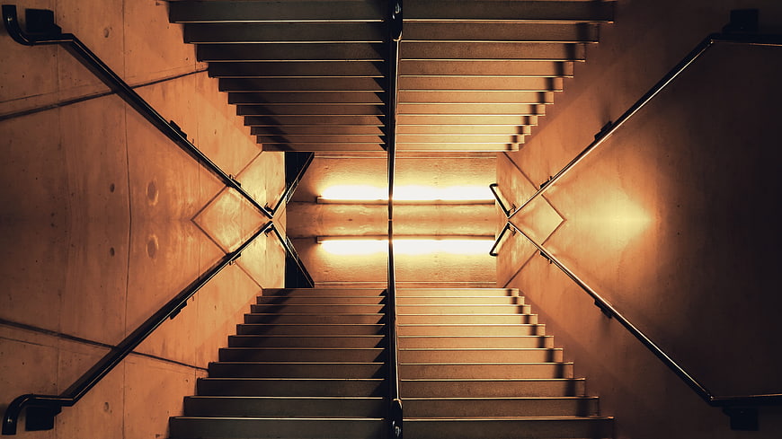 Symmetrical Staircase with Dramatic Lighting and Handrails