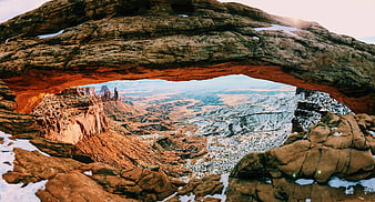 Natural Rock Arch Overlooking Snowy Canyon Landscape