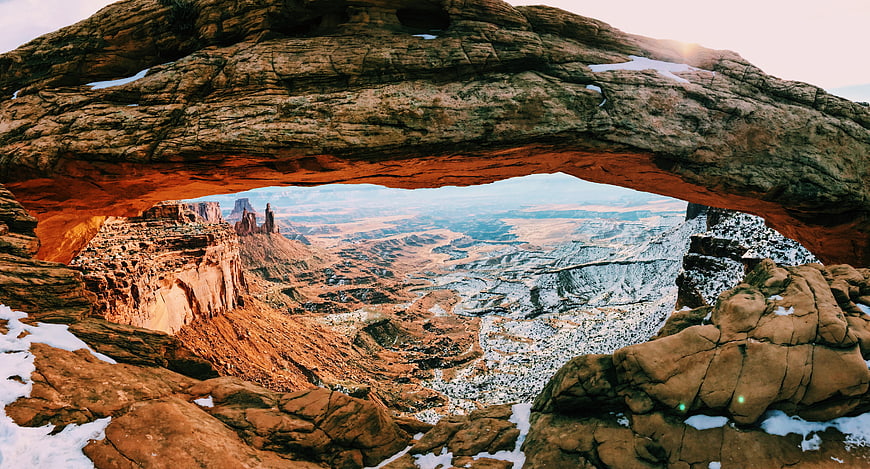 Natural Rock Arch Overlooking Snowy Canyon Landscape