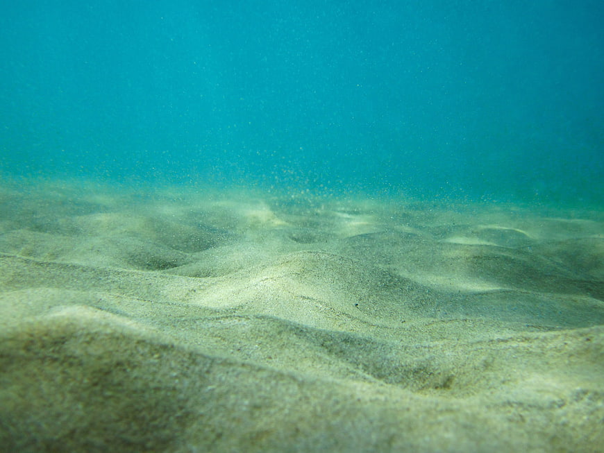 Underwater Sandy Ocean Floor with Blue Water Background