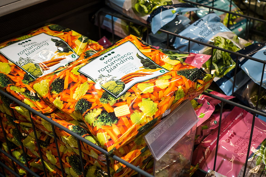 Frozen vegetable mix bags in supermarket freezer basket
