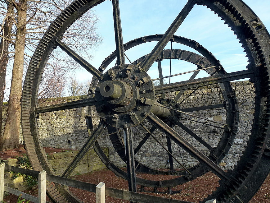 Large vintage industrial water wheel gears against stone wall