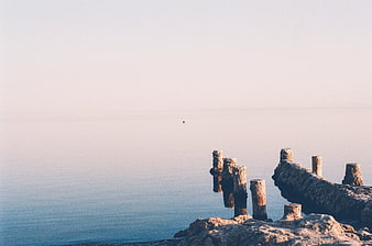 Serene Sea View with Weathered Wooden Pilings and Rocks