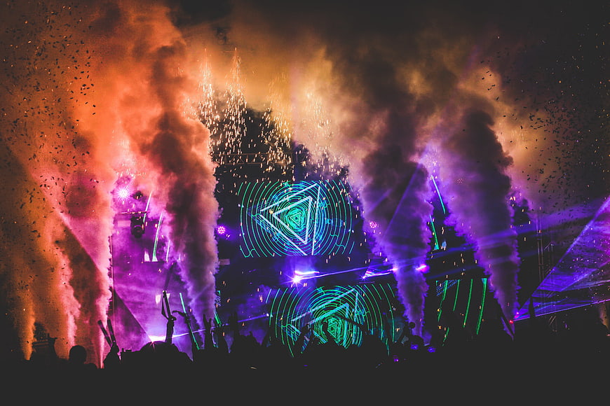 Vibrant EDM Festival Stage With Pyrotechnics, Smoke, And Neon Lights