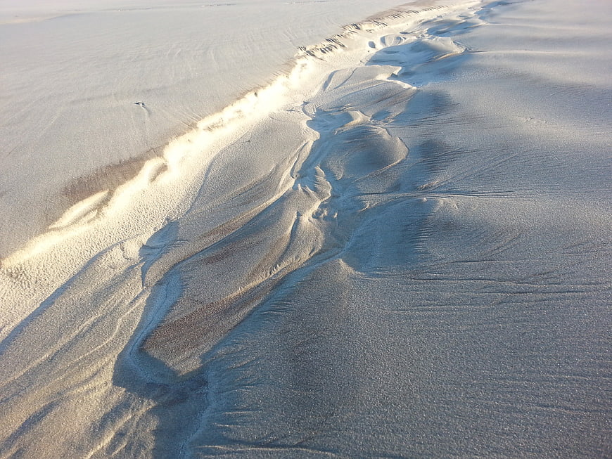 Aerial view of wind-sculpted sand dunes with intricate patterns