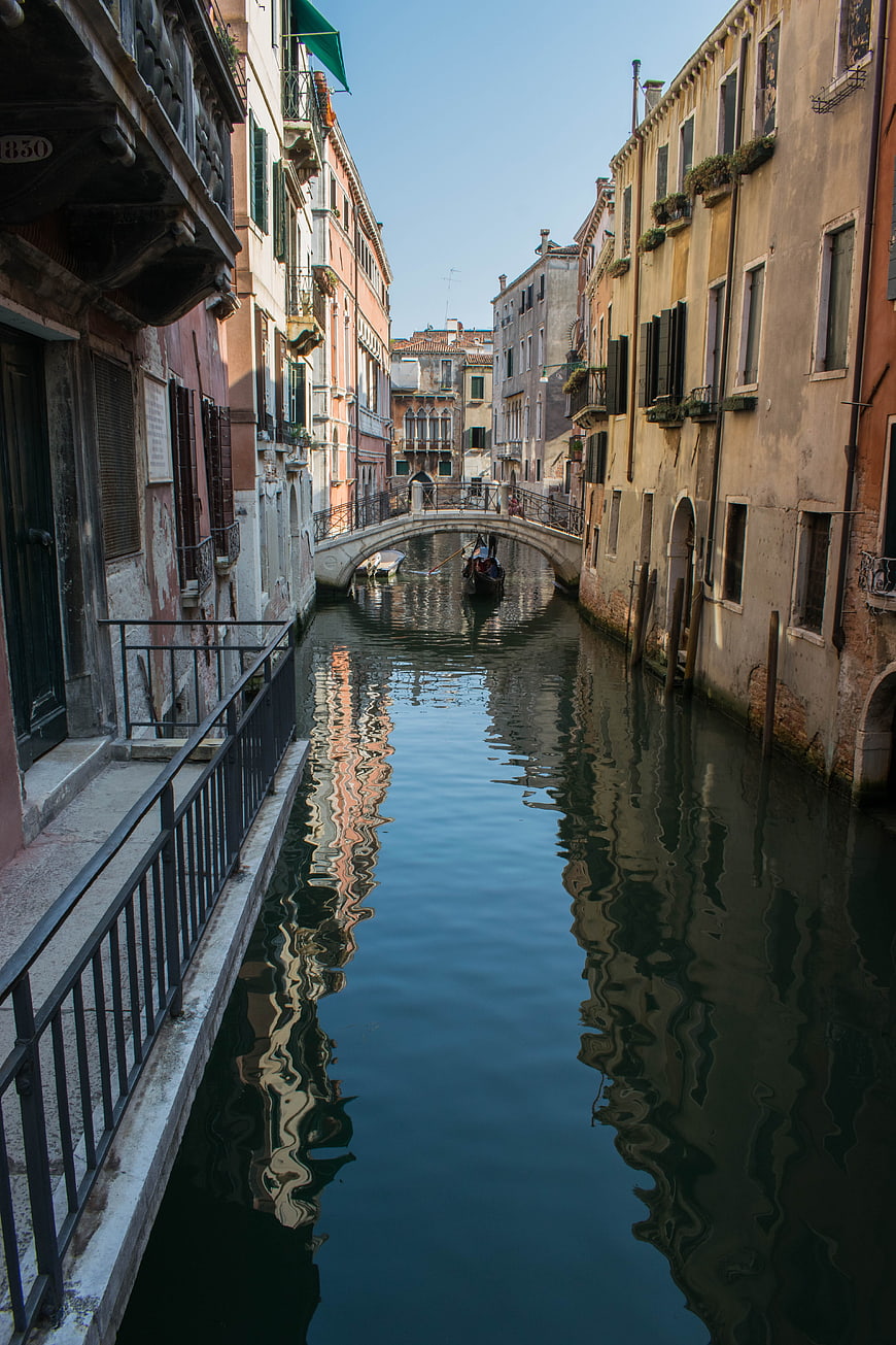 Gondola passing under bridge in Venice canal