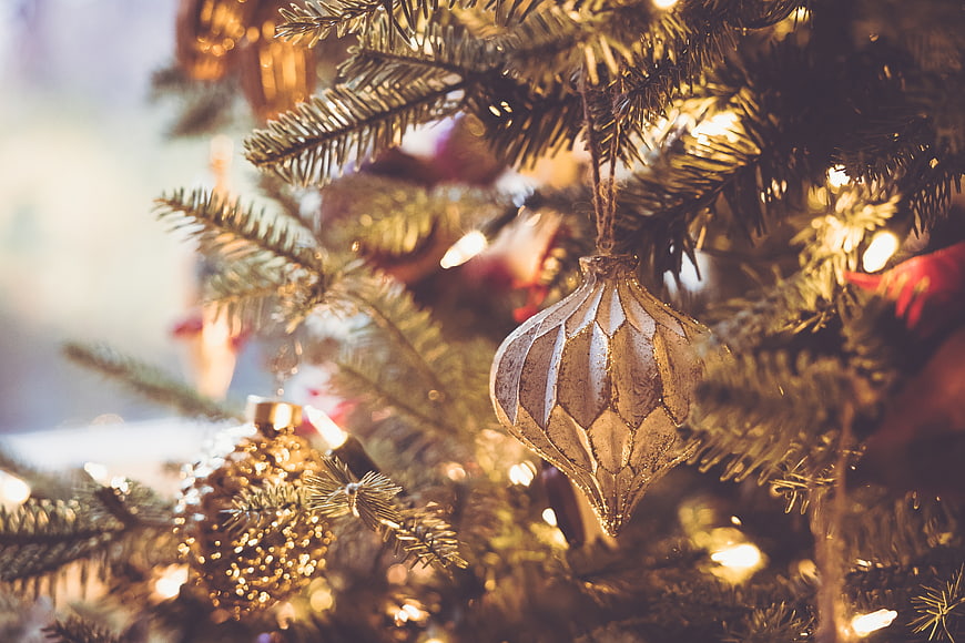 Close-up of vintage gold Christmas ornament on pine tree