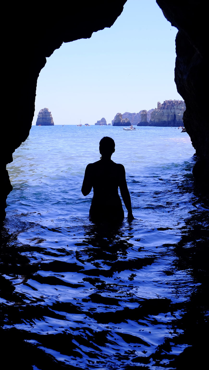 Woman Silhouette in Sea Cave Looking at Ocean Cliffs