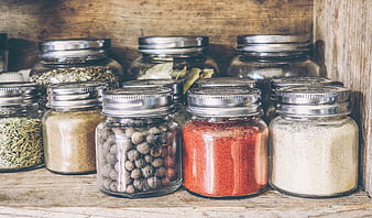 Rustic Glass Jars Filled With Assorted Spices On Wooden Shelf