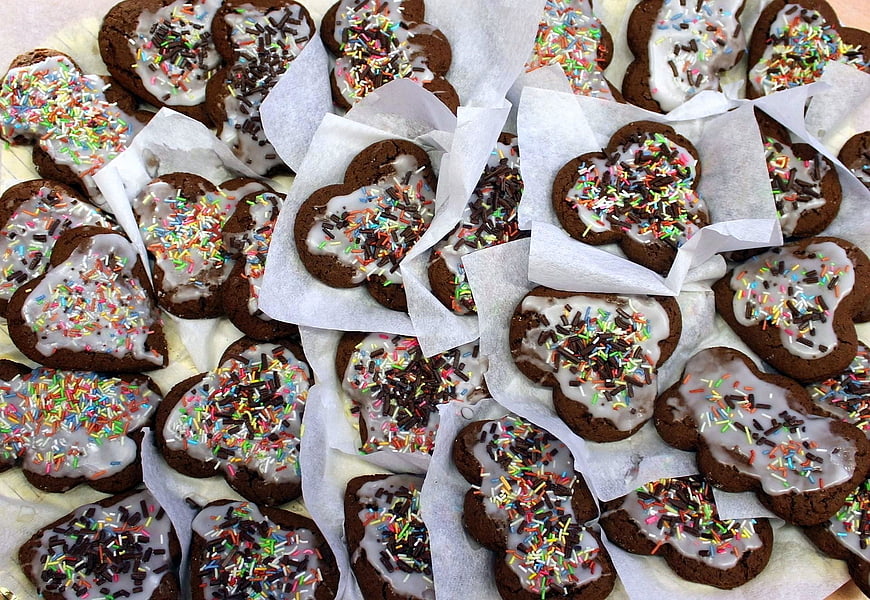 Heart-shaped chocolate cookies with white icing and sprinkles