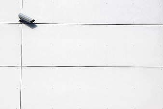 Minimalist Security Camera on White Wall