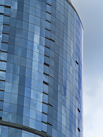 Modern Curved Glass Skyscraper Facade with Blue Sky Reflections