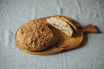 Freshly baked rustic sourdough bread loaf on wooden board