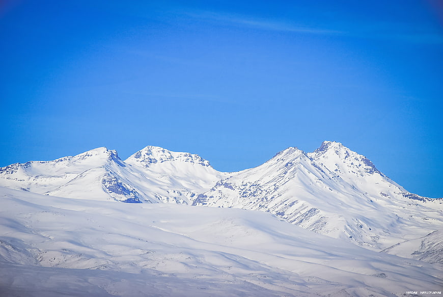 Snow-covered mountain peaks under a clear blue sky