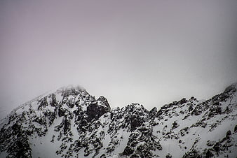 Snowy mountain peaks shrouded in thick fog and mist