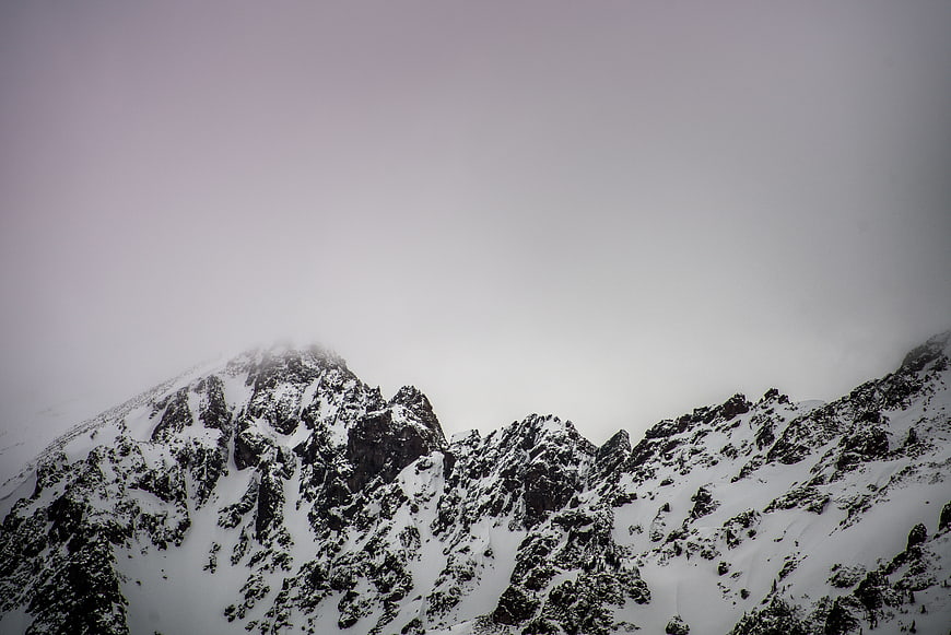 Snowy mountain peaks shrouded in thick fog and mist