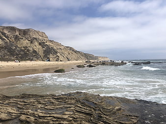 Scenic Crystal Cove Beach with Rocky Foreground and Cliffs