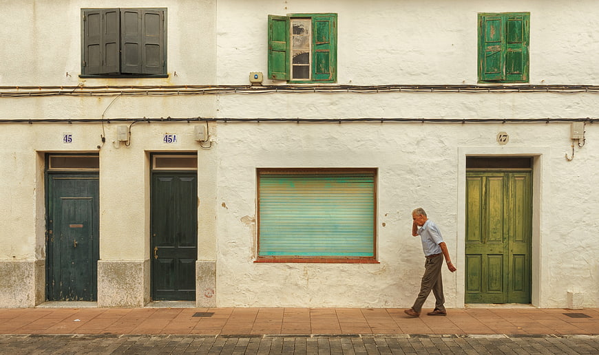 Senior man walking on street talking on mobile phone
