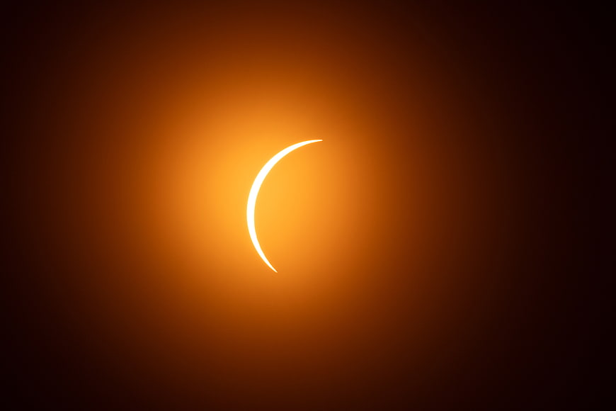 Crescent Solar Eclipse with Golden Orange Glow