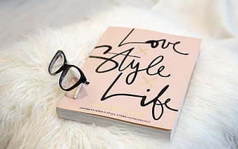 Pink book with glasses on white fur background