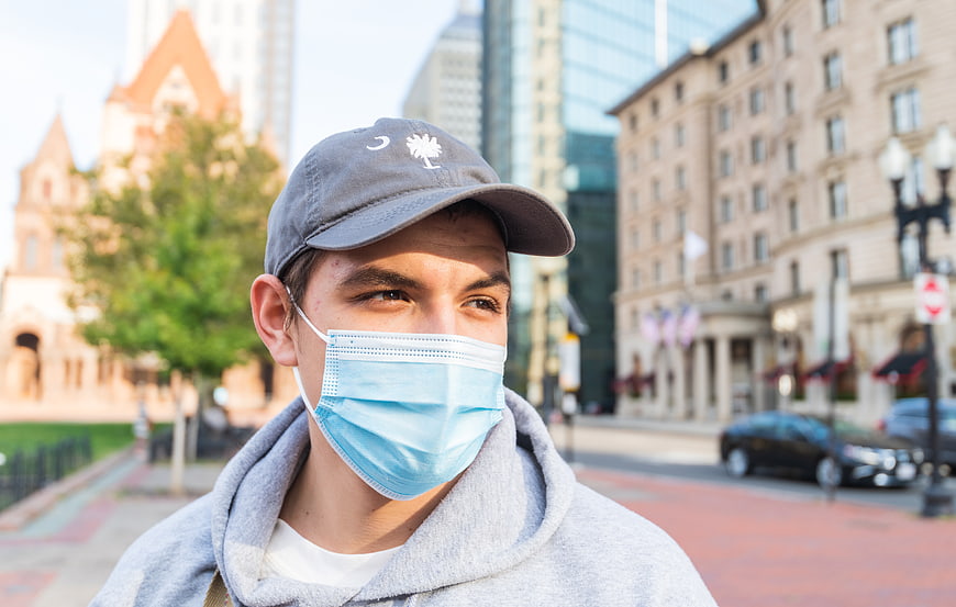 Young Man Wearing Face Mask and Cap on City Street