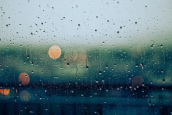 Raindrops on Window Glass with Blurred Bokeh Lights