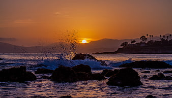 Dramatic Ocean Sunset with Splashing Waves on Rocks