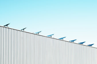 Solar Panels on Industrial Roof Against Blue Sky