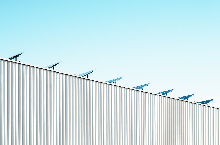 Solar Panels on Industrial Roof Against Blue Sky