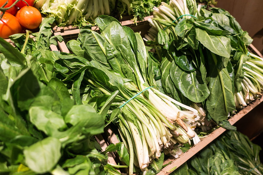 Fresh Bunches of Pak Choi and Vegetables in Wooden Crates
