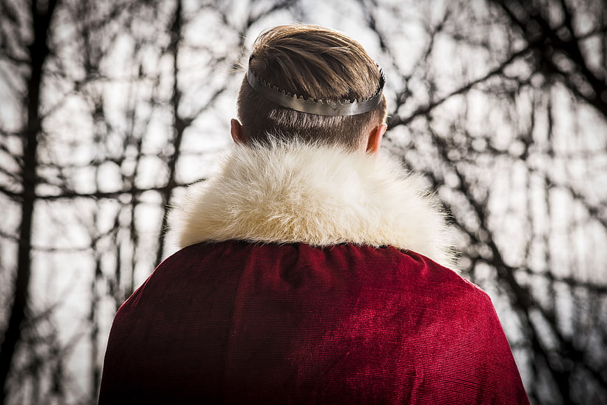 Man in Red Velvet Cape and Iron Crown in Forest