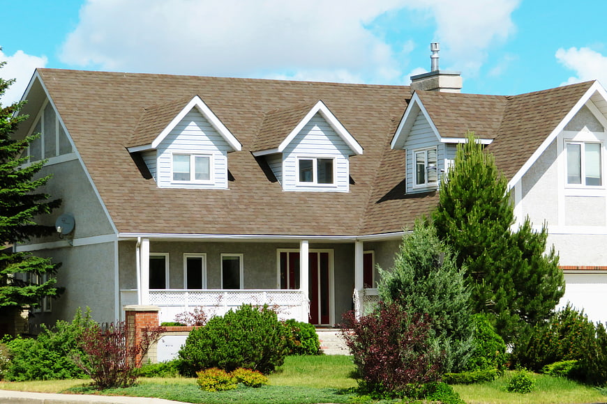 Suburban house with brown shingles and green lawn