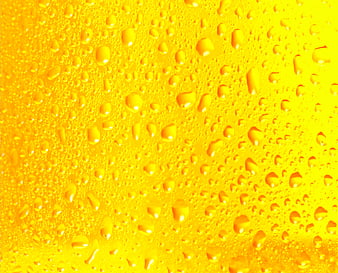 Close-up of condensation droplets on a cold yellow beverage