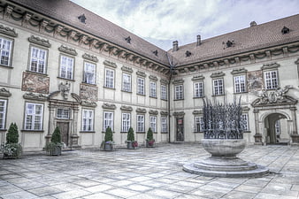 Historic European Courtyard with Stone Fountain and Frescoes