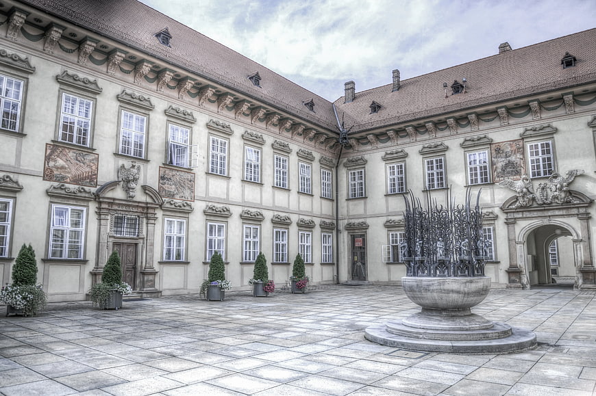 Historic European Courtyard with Stone Fountain and Frescoes