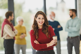 Confident Business Woman Smiling with Coffee in Office