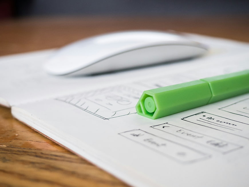 Green marker on wireframe sketch with computer mouse
