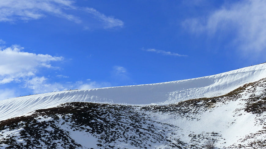 Snowy Mountain Slope Under Blue Sky