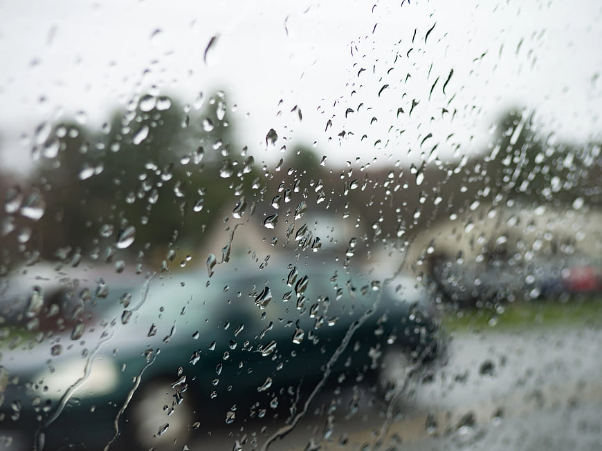 Raindrops on Car Window with Blurred Background