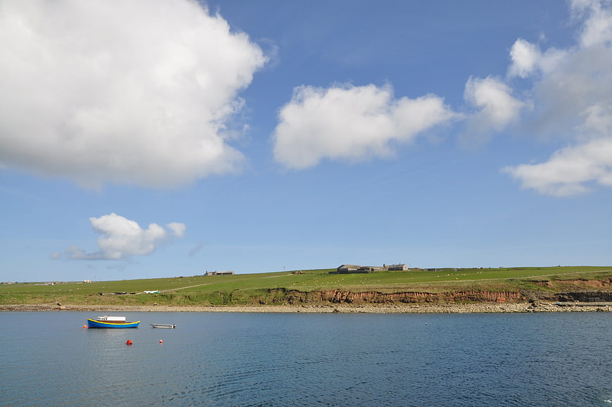 Serene coastal landscape with blue boat and green cliffs