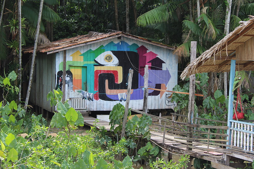 Colorful graffiti art on wooden stilt house in tropical jungle