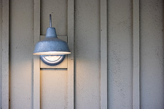 Rustic metal barn light fixture on wooden siding