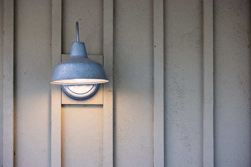 Rustic metal barn light fixture on wooden siding