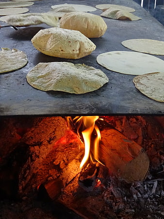 Traditional handmade tortillas cooking on a wood-fired comal