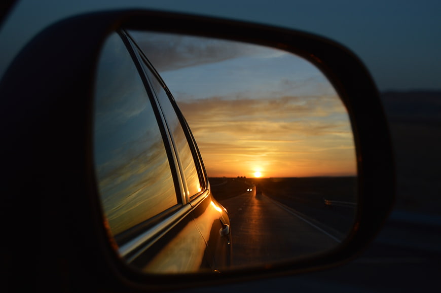 Sunset Reflection in Car Side Mirror on Highway