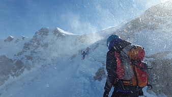 Mountaineer hiking in snowy blizzard conditions