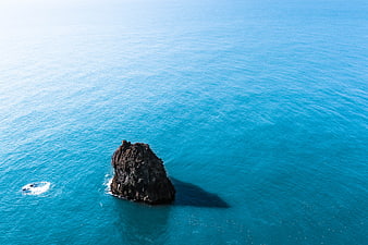 Aerial View of Solitary Rock in Turquoise Ocean