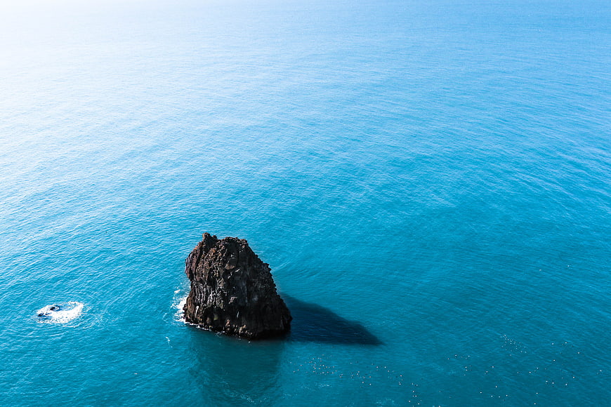 Aerial View of Solitary Rock in Turquoise Ocean